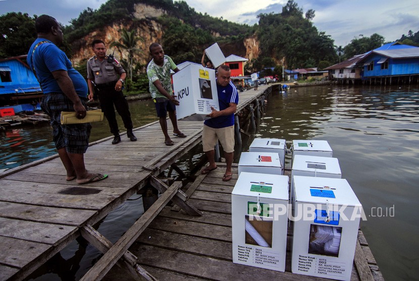 Petugas membawa kotak suara ketika melakukan pendistribusian logistik Pemilu 2019 di Kampung Kayu Pulo, Jayapura, Papua, Selasa (16/4/2019).
