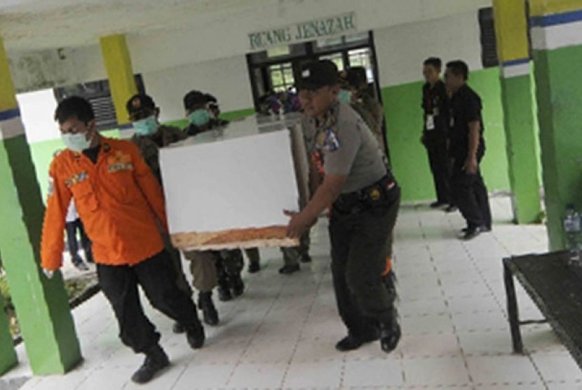 Petugas membawa peti jenazah korban Air Asia QZ8501 di Rumah Sakit Sultan Imanuddin, Pangkalan Bun, Kalimantan Tengah, Kamis (1/1).