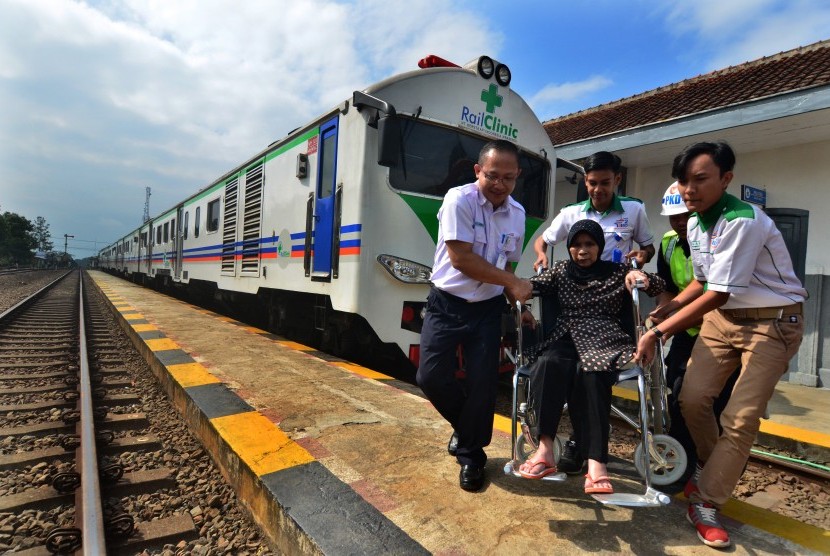 Petugas membawa warga menggunakan kursi roda usai mejalani pengobatan gratis Rail Clinic atau kereta kesehatan di Stasiun Ciawi, Kabupaten Tasikmalaya, Jawa Barat, Selasa (24/7)