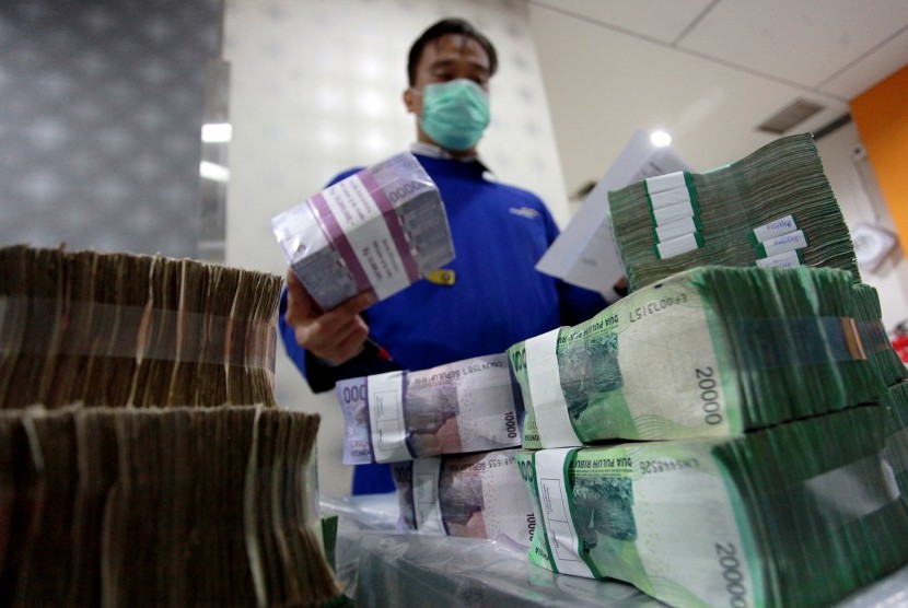Petugas membenahi tumpukan uang di Cash Center Bank Mandiri, Jakarta, Rabu (24/6).