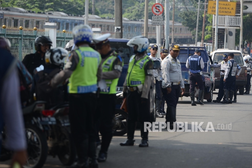 Petugas memberhentikan kendaraan untuk memeriksa kelengkapan surat kendaraan saat menggelar Operasi Zebra Jaya di Pasar Minggu, Kamis (17/11)