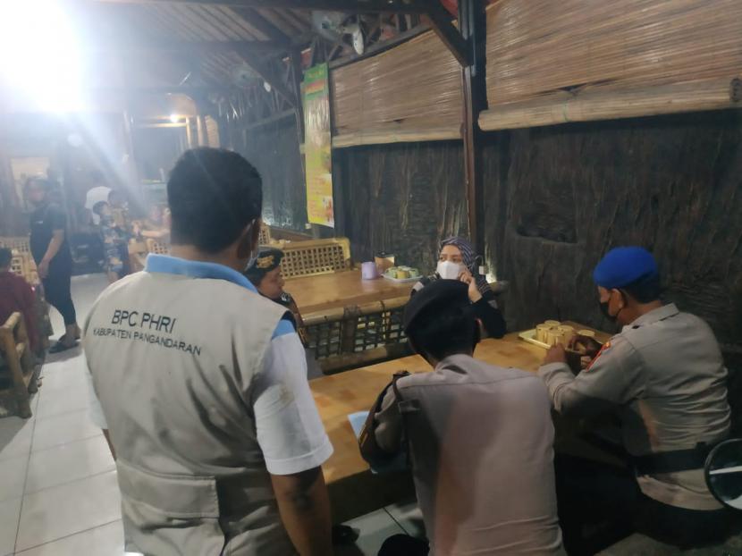 Petugas memberi sanksi tipiring kepada pelaku usaha yang tak menerapkan prokes di kawasan Pantai Pangandaran, Kabupaten Pangandaran, Sabtu (8/1).