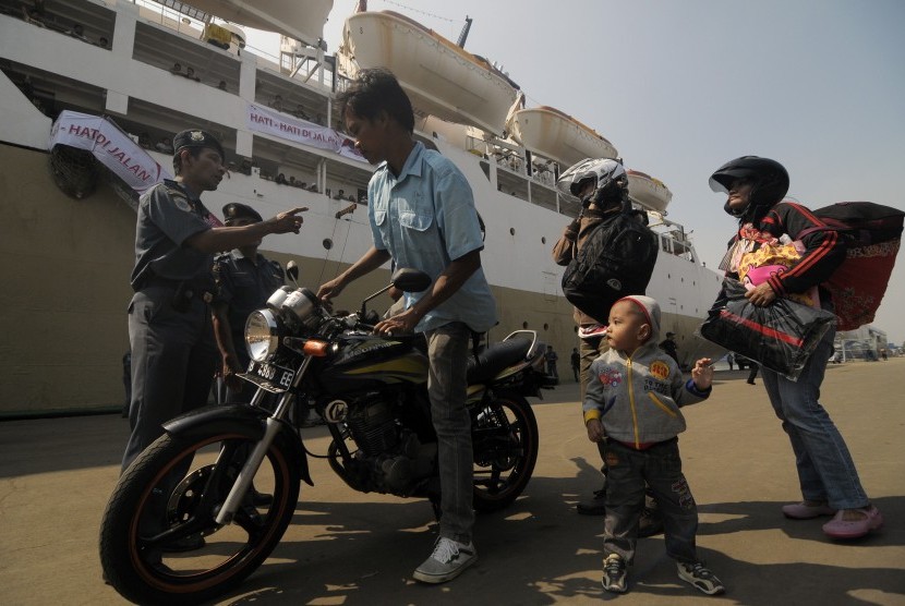 Petugas memberikan arahan kepada pemudik sepeda motor saat akan menaiki kapal saat pelepasan mudik gratis Pelni menggunakan KM Dobonsolo di pelabuhan penumpang Tanjung Priok, Jakarta , Sabtu (3/8). 