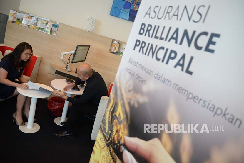 Petugas memberikan informasi kepada nasabah asuransi syariah di kantor layanan Sun Life Financial, Jakarta.