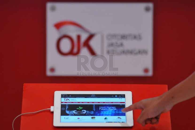 Petugas memberikan informasi mengenai Otoritas Jasa Keuangan (OJK) kapada pengunjung dalam pameran Indonesia Financial Expo & Forum (IFEF) 2014 di Jakarta Convention Center (JCC), Jumat (26/9).(Republika/Prayogi)