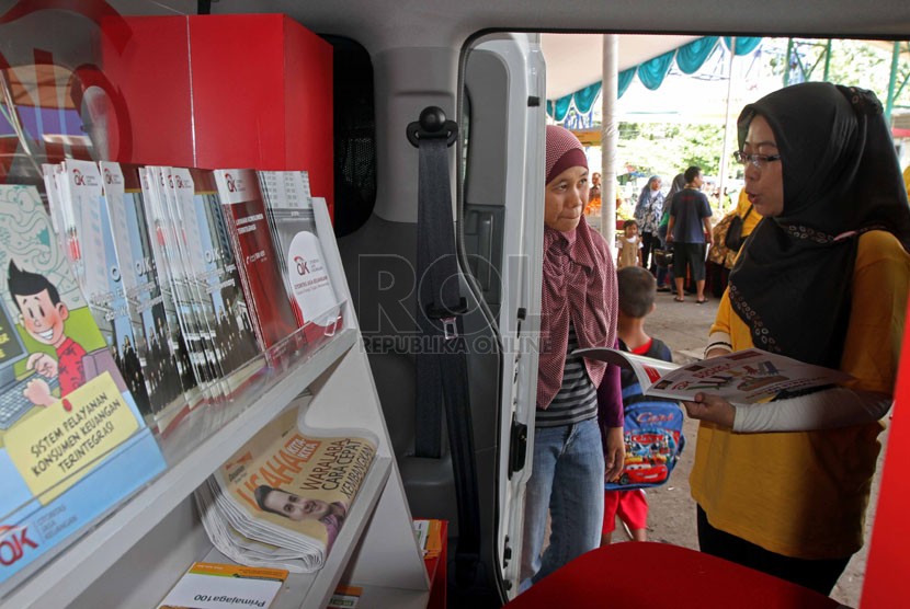   Petugas memberikan penyuluhan kepada warga saat peresmian sosialisasi Si MObil LitErasi Keuangan (SiMOLEK) di Pasar Juanda, Bekasi, Jawa Barat, Senin (5/5). (Republika/Adhi Wicaksono)