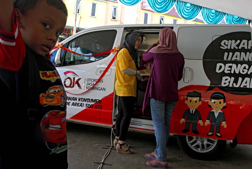 Petugas memberikan penyuluhan kepada warga saat peresmikan sosialisasi Si MObil LitErasi Keuangan (SiMOLEK) di Pasar Juanda, Bekasi, Jawa Barat, Senin (5/5).