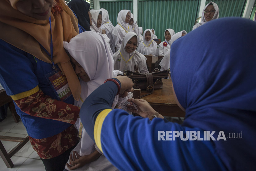 Petugas memberikan vaksin Measless Rubella (MR) kepada pelajar saat acara Pencanangan Kampanye Imunisasi MR di Madrasah Tsanawiah 10, Sleman, DI Yogyakarta, Senin (1/8). 