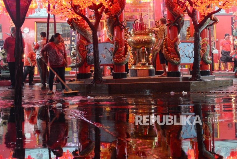   Petugas membersihkan air yang menggenangi Vihara Amurva Bhumi saat banjir, Setiabudi, Jakarta, Ahad (7/2).   (Republika/Raisan Al Fsrisi)