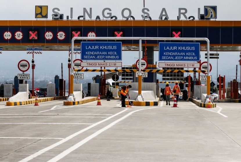 Petugas membersihkan area gerbang tol Singosari yang belum beroperasi di Malang, Jawa Timur, Ahad (12/5).