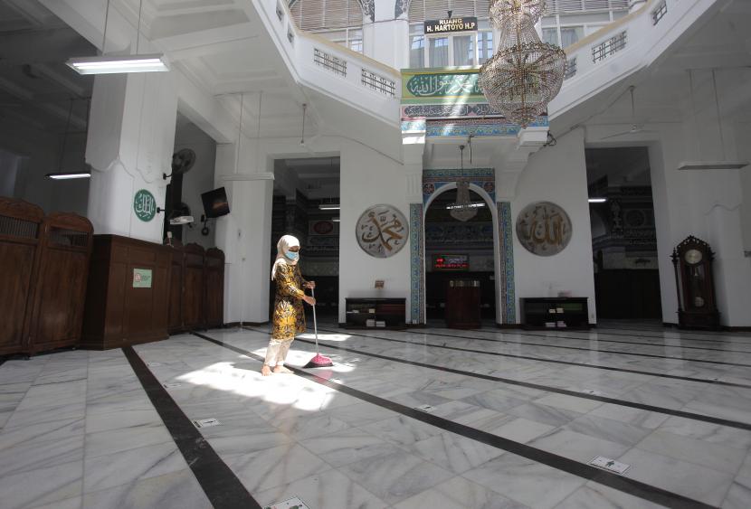 Petugas membersihkan bagian dalam Masjid 
