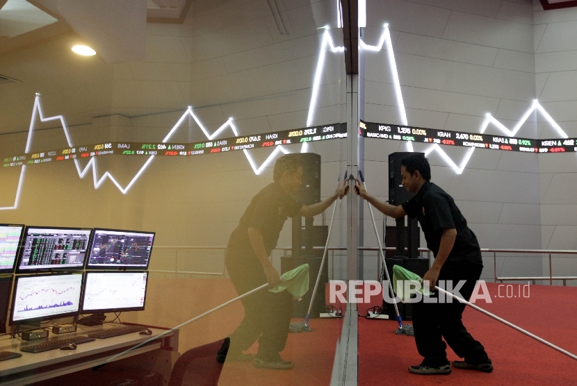 Petugas membersihkan di dekat papan elektronik yang menunjukkan pergerakan indeks harga saham gabungan (IHSG) di gedung Bursa Efek Indonesia, Jakarta, Kamis (7/9).