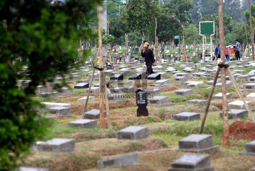 Petugas membersihkan komplek makam di TPU Menteng Pulo, Jakarta Selatan, Jumat (27/11). 