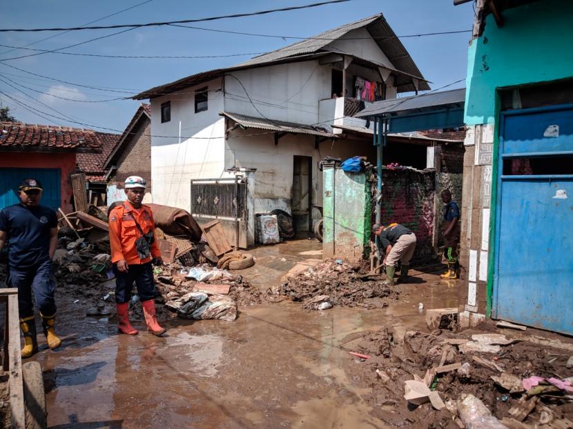 Petugas membersihkan material banjir dan melakukan penyemprotan disinfektan di Kampung Sudika Indah, Kecamatan Tarogong Kidul, Kabupaten Garut, Selasa (19/7/2022). 