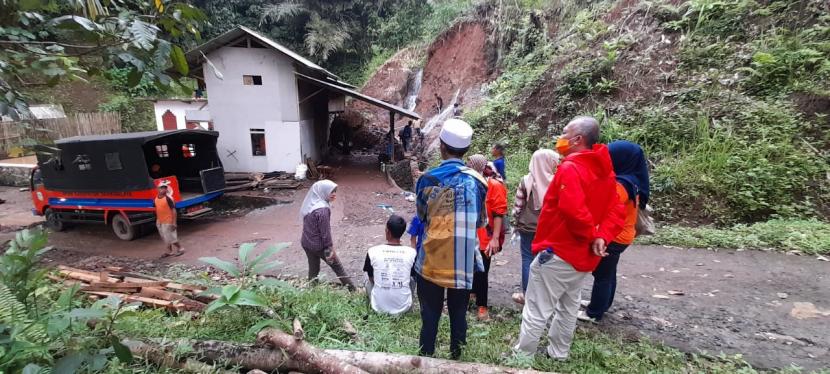 Petugas membersihkan material longsor yang terjadi di Desa Pakemitan, Kecamatan Cikatomas, Kabupaten Tasikmalaya.