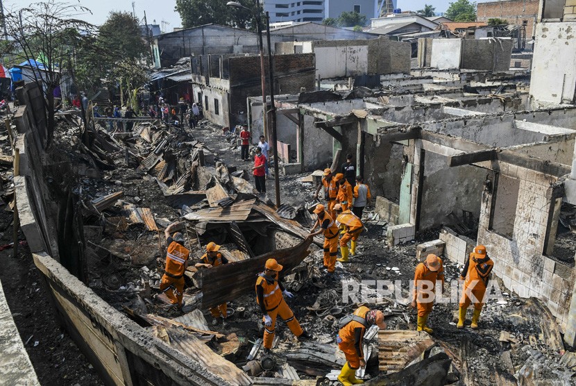 Petugas membersihkan puing-puing sisa kebakaran di kawasan Balimester, Jatinegara, Jakarta, Sabtu (21/9/2019). 