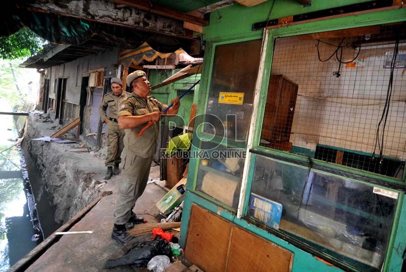 Petugas membongkar bangunan di tepi rel Stasiun Tebet, Jakarta, Senin (18/8). (Republika/ Wihdan).