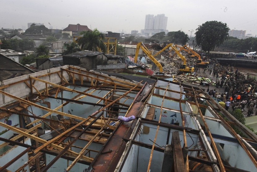 Petugas membongkar bangunan menggunakan alat berat di kawasan Kalijodo, Jakarta, Senin (29/2).