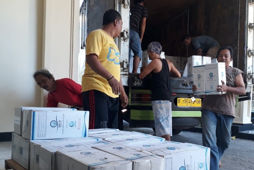 Petugas membongkar ribuan galon air zamzam di Asrama Haji Embarkasi Surabaya (Ahes), Selasa (23/7/2019). Air zamzam ini nantinya akan dibagikan kepada jamaah haji, saat tiba di Tanah Air.