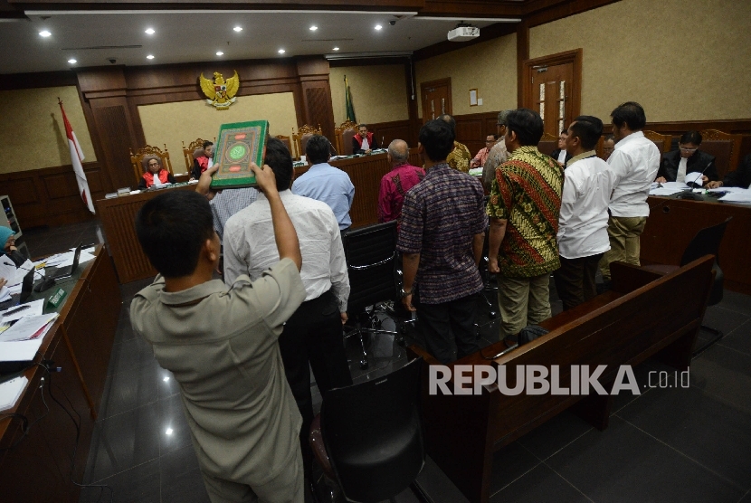 Petugas memegang Kitab Suci Al-Quran saat menyumpah saksi untuk memberikan keterangan dalam sidang dengan dua terdakwa kasus korupsi e-KTP Irman dan Sugiharto di Pengadilan Tipikor, Jakarta, Kamis (13/4).