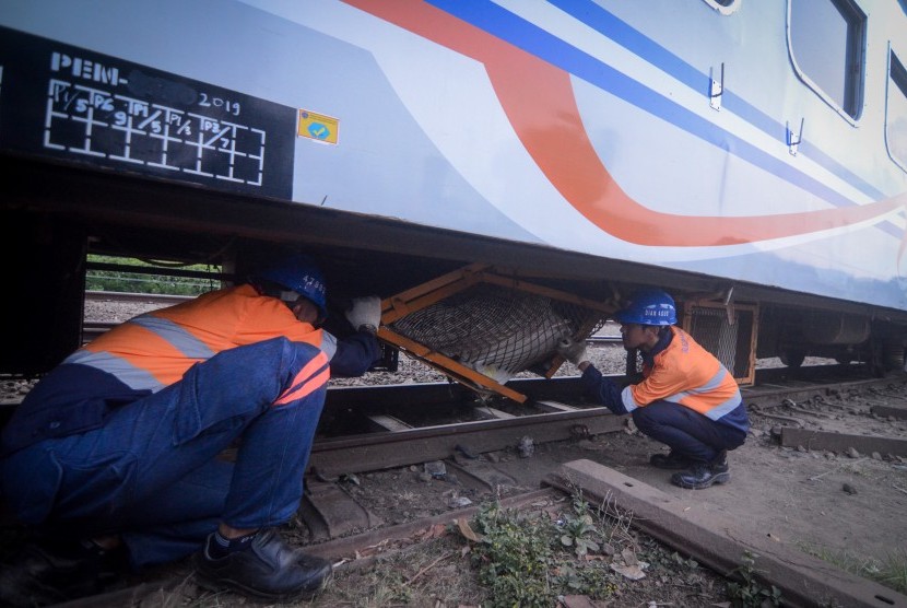 Petugas memeriksa bagian bawah gerbong yang rusak akibat anjloknya kereta api. (Ilustrasi)