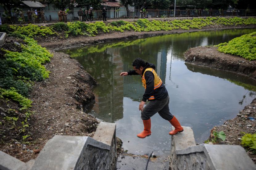 Petugas memeriksa bagian tepi Kolam Retensi di Bandung. Kota dan Kabupaten Bandung akan membangun lebih banyak kolam serupa untuk menghadapi banjir.
