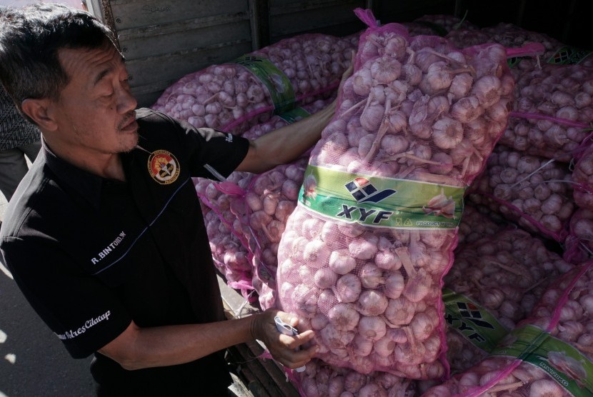 Petugas memeriksa bawang putih sitaan dari kegiatan razia satgas pangan, di Polres Cilacap, Jawa Tengah, Jumat (26/5). Satgas Pangan Polres Cilacap menyita 10 ton bawang putih yang telah disimpan selama satu bulan, oleh pedagang yang tidak dilengkapi dengan dokumen resmi dan tidak terdaftar sebagai distributor resmi di Disperindagkop Kabupaten Cilacap. ANTARA FOTO/Idhad Zakaria/foc/17. 