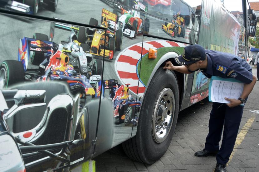 Petugas memeriksa bus yang akan mengangkut pemudik saat mudik gratis. Ilustrasi. Banyuwangi Siapkan Delapan Bus Mudik Gratis dari Bali