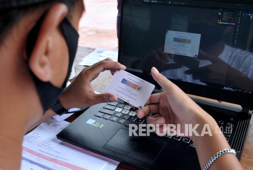 Petugas memeriksa cetakan kartu sertifikat vaksinasi COVID-19 pesanan warga saat kegiatan vaksinasi COVID-19 massal di Denpasar, Bali, Selasa (3/8/2021). Jasa cetak Surat Keterangan Vaksinasi COVID-19 tersebut dijual dengan harga Rp25 ribu per buah.