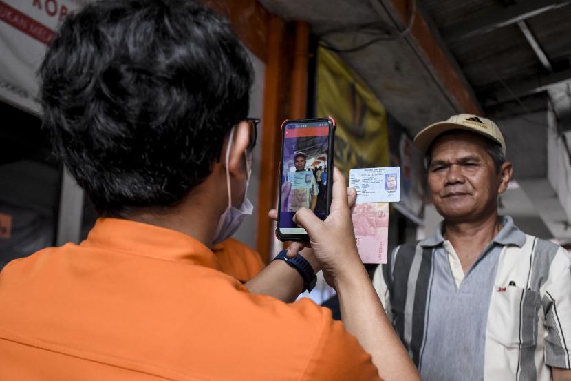 Petugas memeriksa data diri warga saat penyaluran bantuan sosial (bansos) Provinsi Jawa Barat Tahap ke-IV di Kantor Pos Bandung, Jalan Asia Afrika, Kota Bandung.