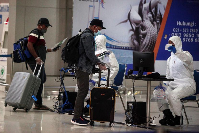 Petugas memeriksa dokumen perjalanan Pekerja Migran Indonesia (PMI) saat tiba di Terminal 2 Bandara Internasional Juanda Surabaya di Sidoarjo, Jawa Timur. 