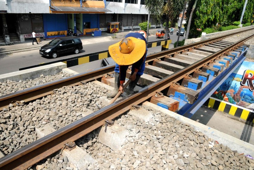 Petugas memeriksa kelurusan rel di ruas jalur kereta api Kampung Bandan - Muara Angke, Jakarta Utara, Ahad (15/4). (Republika/Wihdan Hidayat)