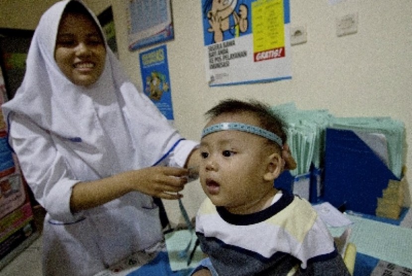   Petugas memeriksa kesehatan balita di Puskesmas Kecamatan Sawah Besar, Jakarta, Kamis (19/3).