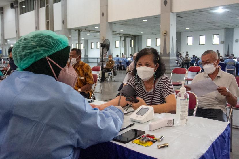 Petugas memeriksa kesehatan calon penerima vaksin booster COVID-19 di Jogja Expo Center, Bantul, DI Yogyakarta, Kamis (13/1/2022). Pemerintah Daerah Istimewa Yogyakarta menggelar vaksinasi booster COVID-19 untuk 4.000 warga dengan prioritas utama lansia.