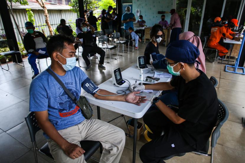 Petugas memeriksa kesehatan calon penerima vaksin Covid-19 dosis ketiga di RPTRA Bhineka, Swadarma, Kecamatan Pesanggrahan, Jakarta Selatan, Kamis (24/3/2022).