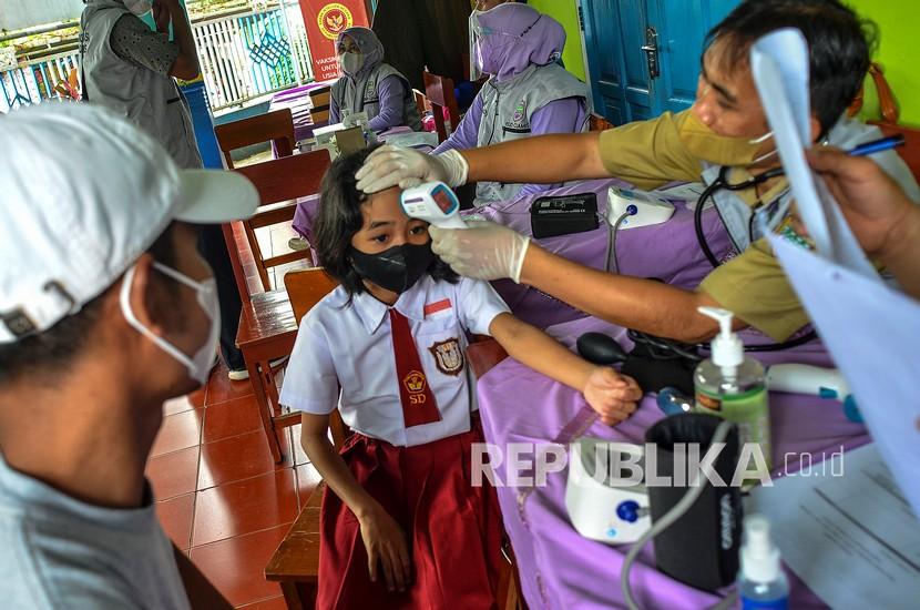 Petugas memeriksa kesehatan siswa sebelum mendapatkan vaksinasi COVID-19 di SDN 7 Ciamis, Kabupaten Ciamis, Jawa Barat, Selasa (21/12/2021). Kementerian Kesehatan menargetkan sebanyak 26,5 juta anak usia 6-11 tahun memenuhi syarat untuk vaksin COVID-19. 