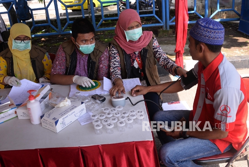  Petugas memeriksa kesehatan sopir angkutan Lebaran di posko kesehatan Terminal Kampung Rambutan, Jakarta, Jumat (24/6). (Republika/ Yasin Habibi)