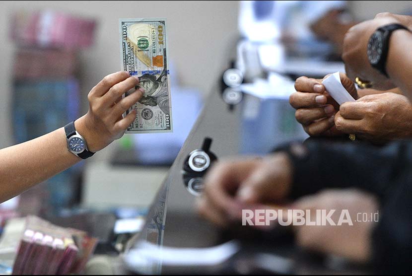 Petugas memeriksa kondisi dolar Amerika Serikat di salah satu gerai penukaran mata uang asing di Jakarta. (ilustrasi).