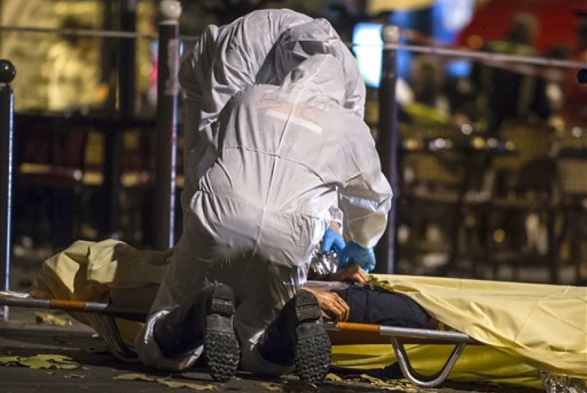 Petugas memeriksa kondisi jenazah korban serangan Paris, Jumat malam waktu setempat (13/11). Presiden Prancis sudah menyatakan negaranya dalam kondisi darurat.