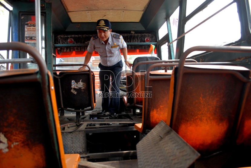  Petugas memeriksa kondisi metromini yang tidak layak jalan di Terminal mobil barang Pulo Gebang , Jakarta Timur, Kamis (30/8). (Republika/Rakhmawaty La'lang)
