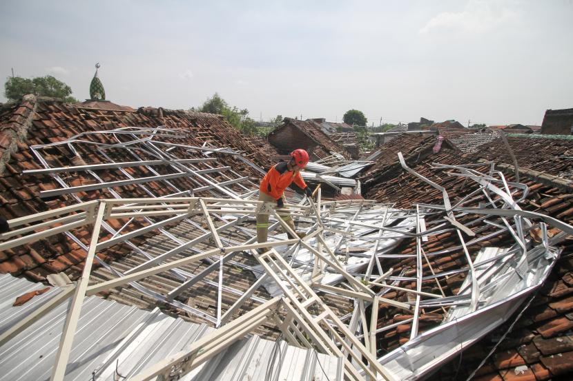 Petugas memeriksa kondisi salah satu rumah warga yang rusak akibat diterjang angin puting beliung di Desa Sidokepung, Buduran, Sidoarjo, Jawa Timur, Senin (24/10/2022). Berdasarkan data Badan Penanggulangan Bencana Daerah (BPBD) Sidoarjo mencatat sedikitnya 291 rumah warga rusak akibat diterjang puting beliung yang terjadi pada Ahad (23/10). 