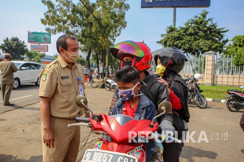 Petugas memeriksa pengendara saat penerapan Pembatasan Sosial Berskala Besar (PSBB) di jalan M.H Thamrin, Cikokol, Kota Tangerang, Banten, Sabtu (18/4/2020). Pemerintah telah resmi menerapkan PSBB di wilayah Tangerang Raya per hari ini dalam rangka percepatan penanganan COVID-19.