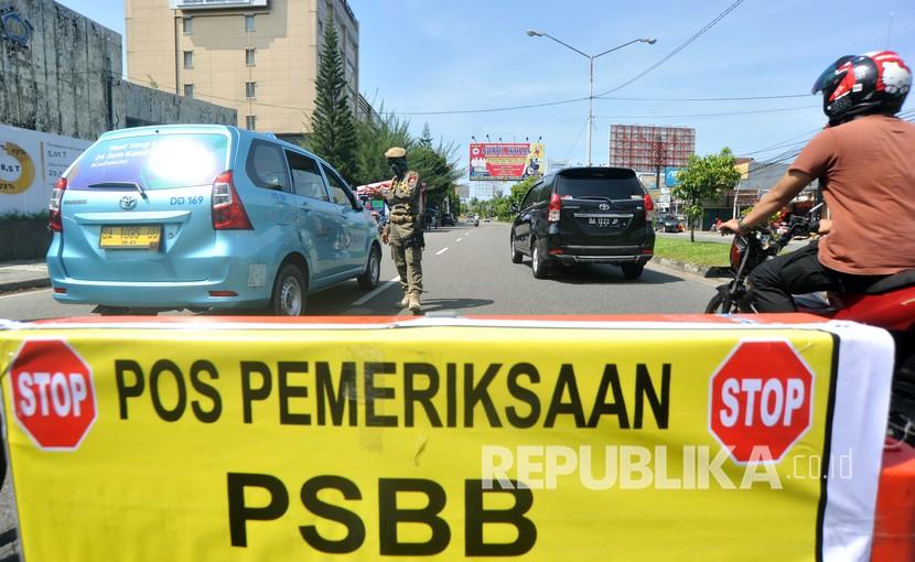Petugas memeriksa penumpang di dalam kendaraan yang melintas di Posko Check Point Pembatasan Sosial Berskala Besar (PSBB) di Air Tawar, Padang, Sumatera Barat, Rabu (22/4/2020). PSBB diterapkan di Padang dan kabupaten/ kota lain di provinsi itu mulai Rabu (22/4/2020) hingga 5 Mei 2020 untuk menghentikan penyebaran COVID-19, diantaranya dengan membatasi aktivitas di luar rumah, wajib menggunakan masker serta pembatasan jumlah penumpang kendaraan roda empat dan roda dua. 