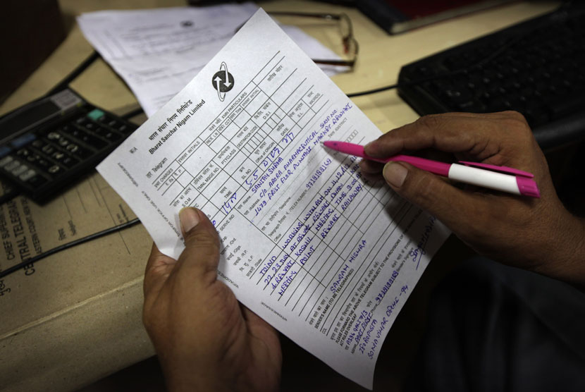 Petugas memeriksa pesan telegram dari pelanggan di kantor telegram Kashmere Gate di New Delhi, India.   (AP/Manish Swarup)  