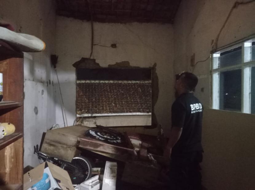 Petugas memeriksa rumah warga yang mengalami kerusakan akibat diterjang hujan deras disertai angin puting beliung di Desa Leles, Kecamatan Leles, Kabupaten Garut, Senin (24/1/2022).