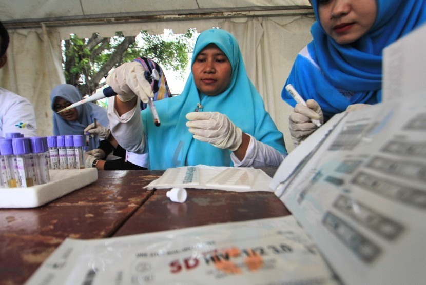 Petugas memeriksa sampel darah saat pemeriksaan HIV/AIDS gratis dalam rangka memperingati hari AIDS sedunia di Indramayu, Jawa Barat, Sabtu (1/12/2018). 