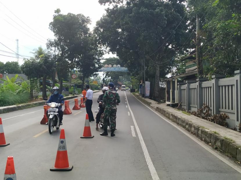 Petugas memeriksa sejumlah orang yang masuk ke wilayah Kota Tasikmalaya di posko perbatasan Kecamatan Indihiang, Ahad (26/4).