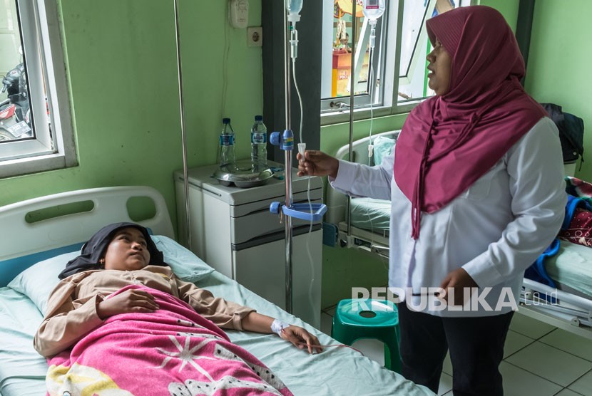 Petugas memeriksa seorang pelajar yang diduga keracunan makanan saat menjalani perawatan di Puskesmas Karangawen I di Demak, Jawa Tengah, Jumat (26/1). 