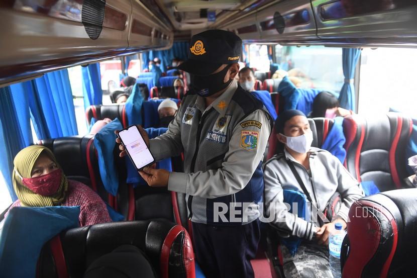 Petugas memeriksa serifikat vaksinasi penumpang bus antar kota antar provinsi (AKAP) di Terminal Kampung Rambutan, Jakarta, Kamis (6/1/2022). Penerapan protokol kesehatan yang ketat pada moda transportasi dilaksanakan untuk mencegah penyebaran varian baru COVID-19 yakni B.1.1.529 atau Omicron.