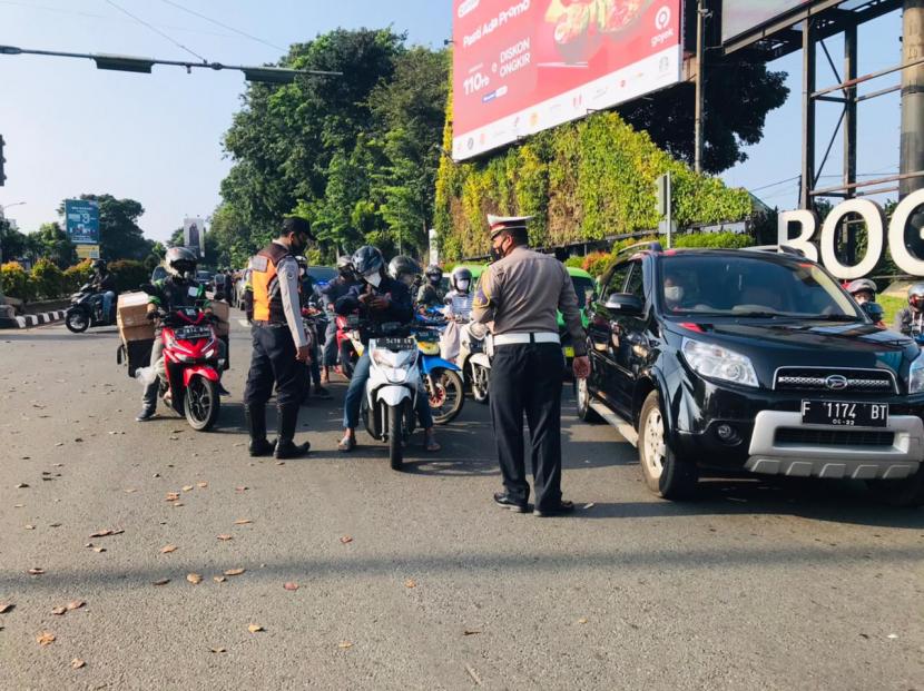 Petugas memeriksa STRP dari para pekerja yang hendak masuk ke Kota Bogor di Simpang Baranangsiang, Rabu (7/7).